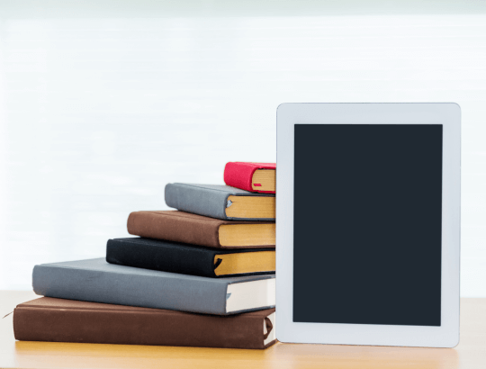 Livros físicos e um dispositivo e-book representando os livros digitais