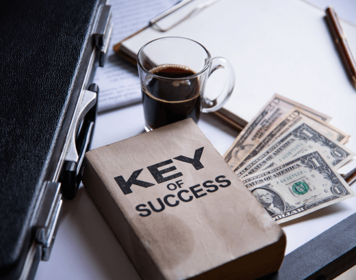 livro de título key of success sobre notas de dolares em uma mesa